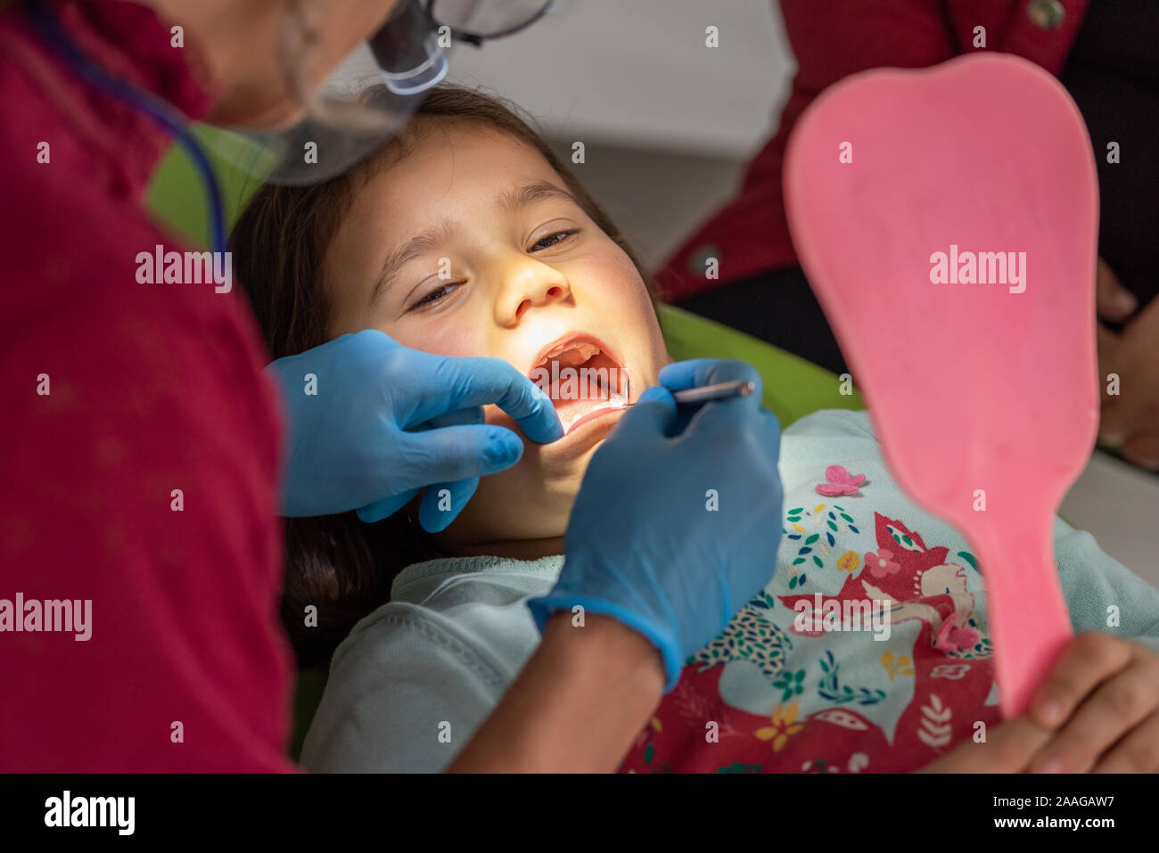 Dentist examining young girl in dental clinic Stock Photo