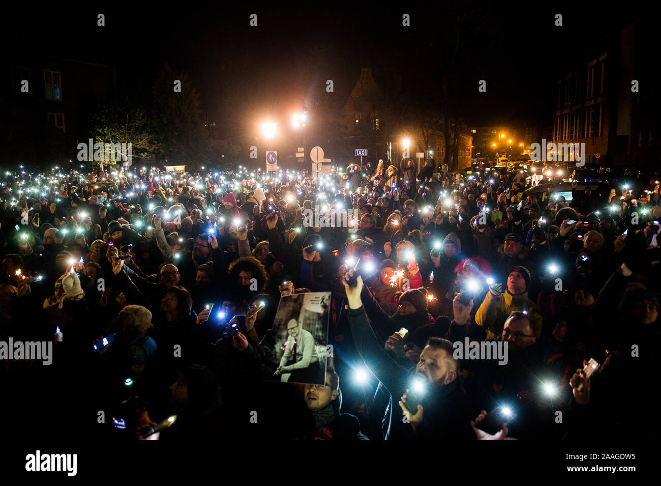 Protesters use phones to shine light during the demonstration called Light to heaven for Pawel Adamowicz at the Coal Market in Gdansk.  Mayor of Gdansk, Pawel Adamowicz was stabbed on stage while attending a charity event in Gdansk on 13 January and died a day later of his injuries. Stock Photo