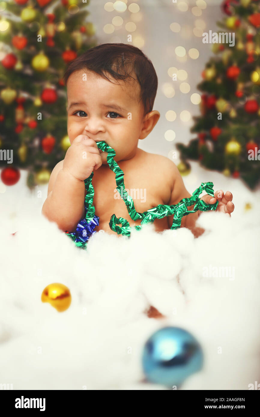 Little cute baby celebrating christmas festival with in decorative background on the occasion. Stock Photo