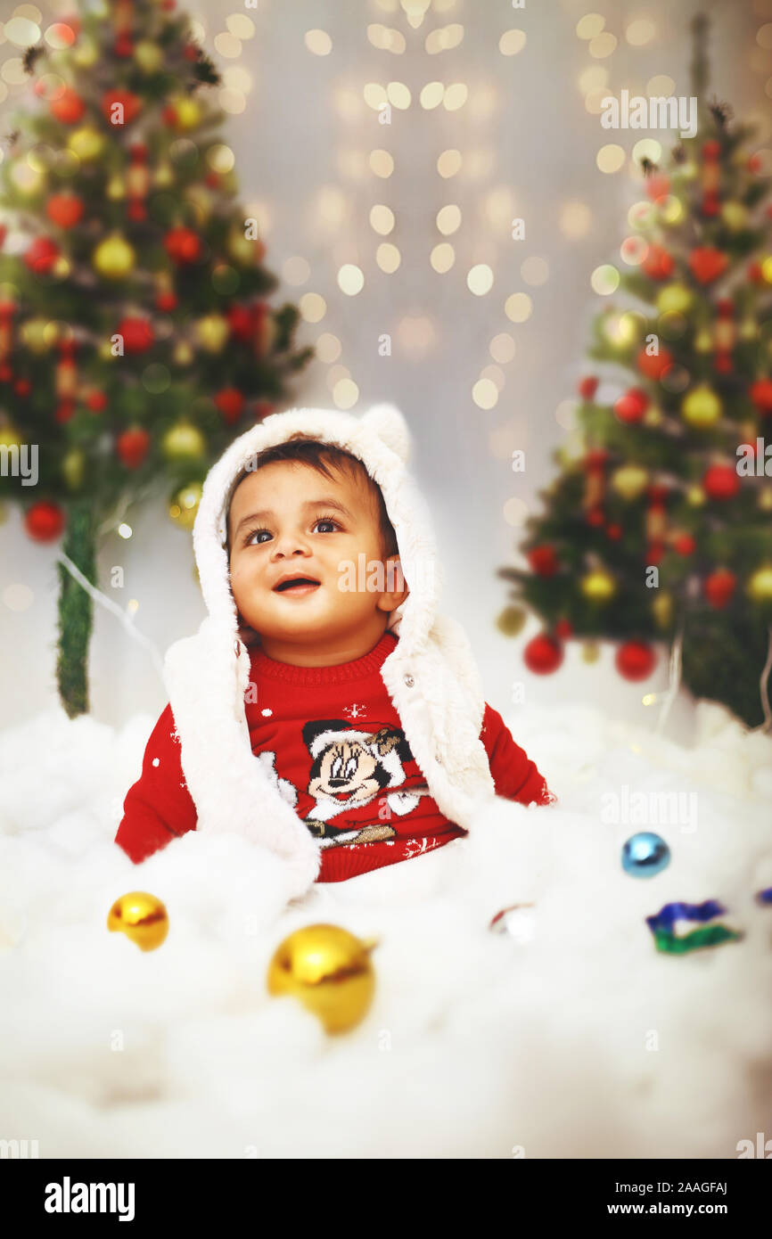 Little cute baby celebrating christmas festival with in decorative background on the occasion. Stock Photo