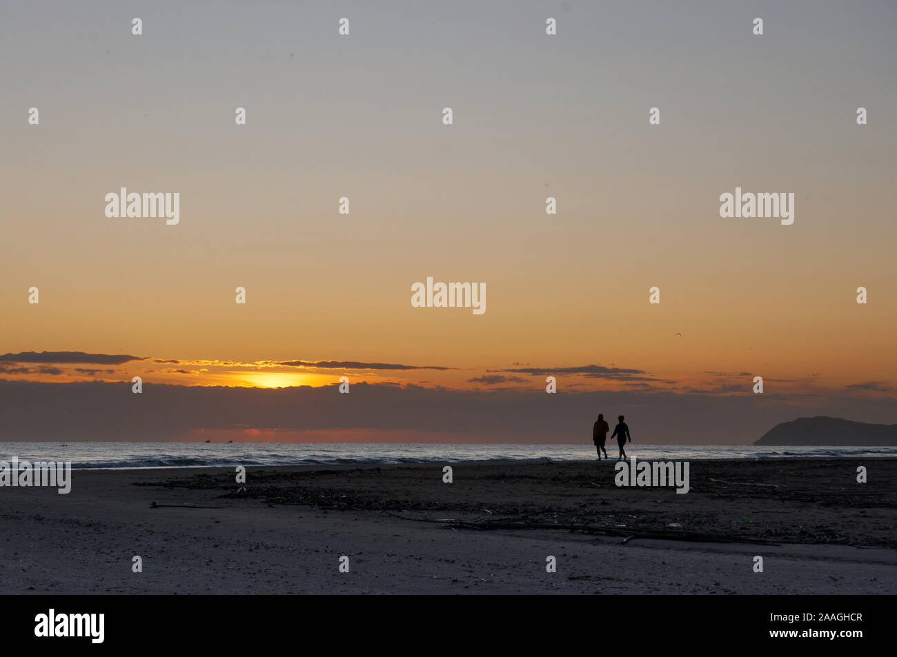sunrise view and silhouette of couple walking on the beach Stock Photo ...
