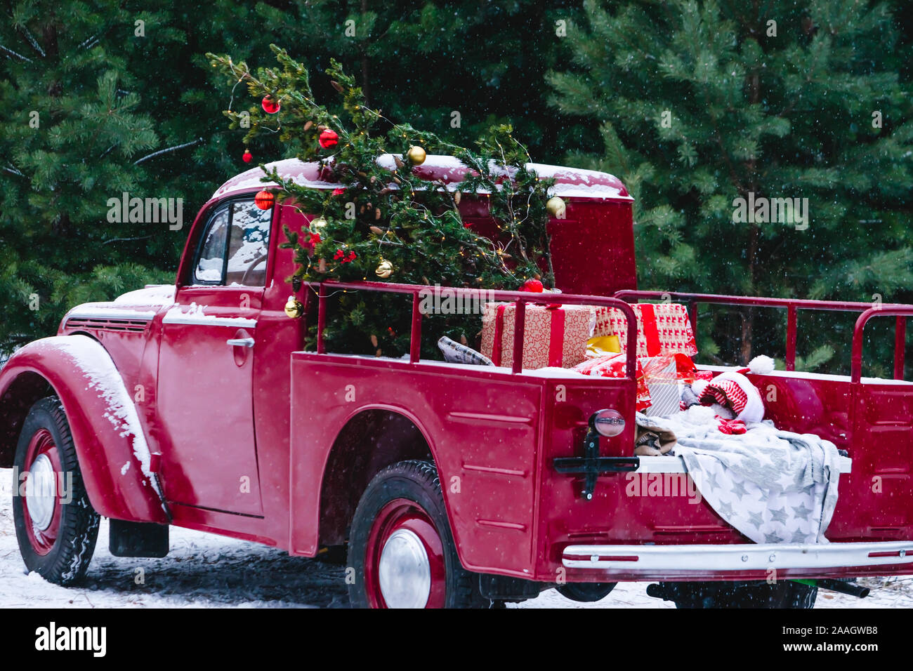 A Red Car With Christmas Decorations And A Christmas Tree Is