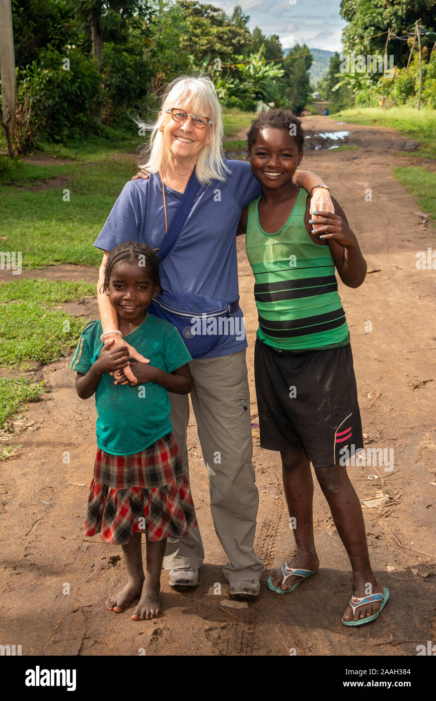 Ethiopia, South Omo, Jinka, Yenegrew Sew Aari village, western tourist with two young Ari tribe girls Stock Photo