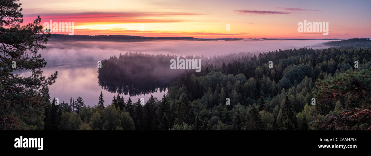 Scenic landscape with lake, sunrise and fog at tranquil misty morning in Aulanko, nature reserve, Finland Stock Photo