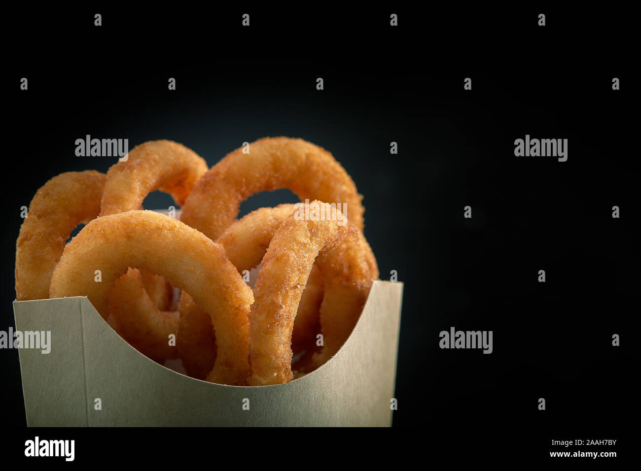 Onion Rings Paper Onion Rings in paper From a Fast Food Restaurant on dark background ...