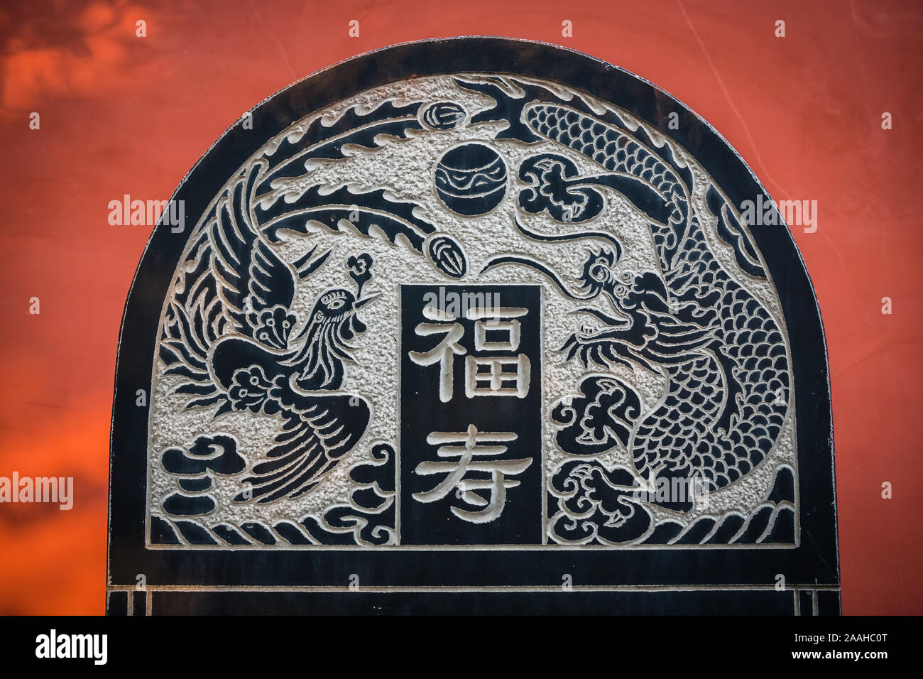 Huashan, China -  August 2019 : Plaque with chinese graphic engravings depicting bird and dragon as well as chinese characters writing, Buddhist Templ Stock Photo