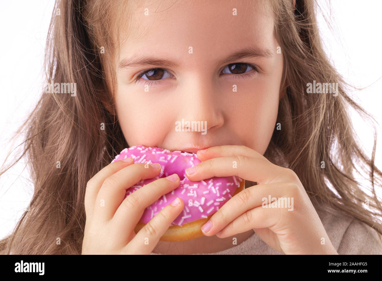 Happy little girl eating pink donut Stock Photo