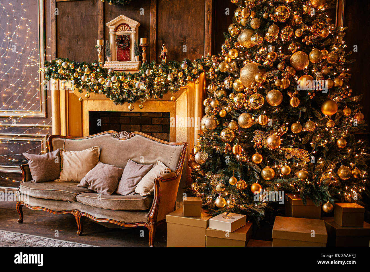 Christmas background with illuminated fir tree with golden decpration and  fireplace in living room. Cozy holiday home Stock Photo - Alamy