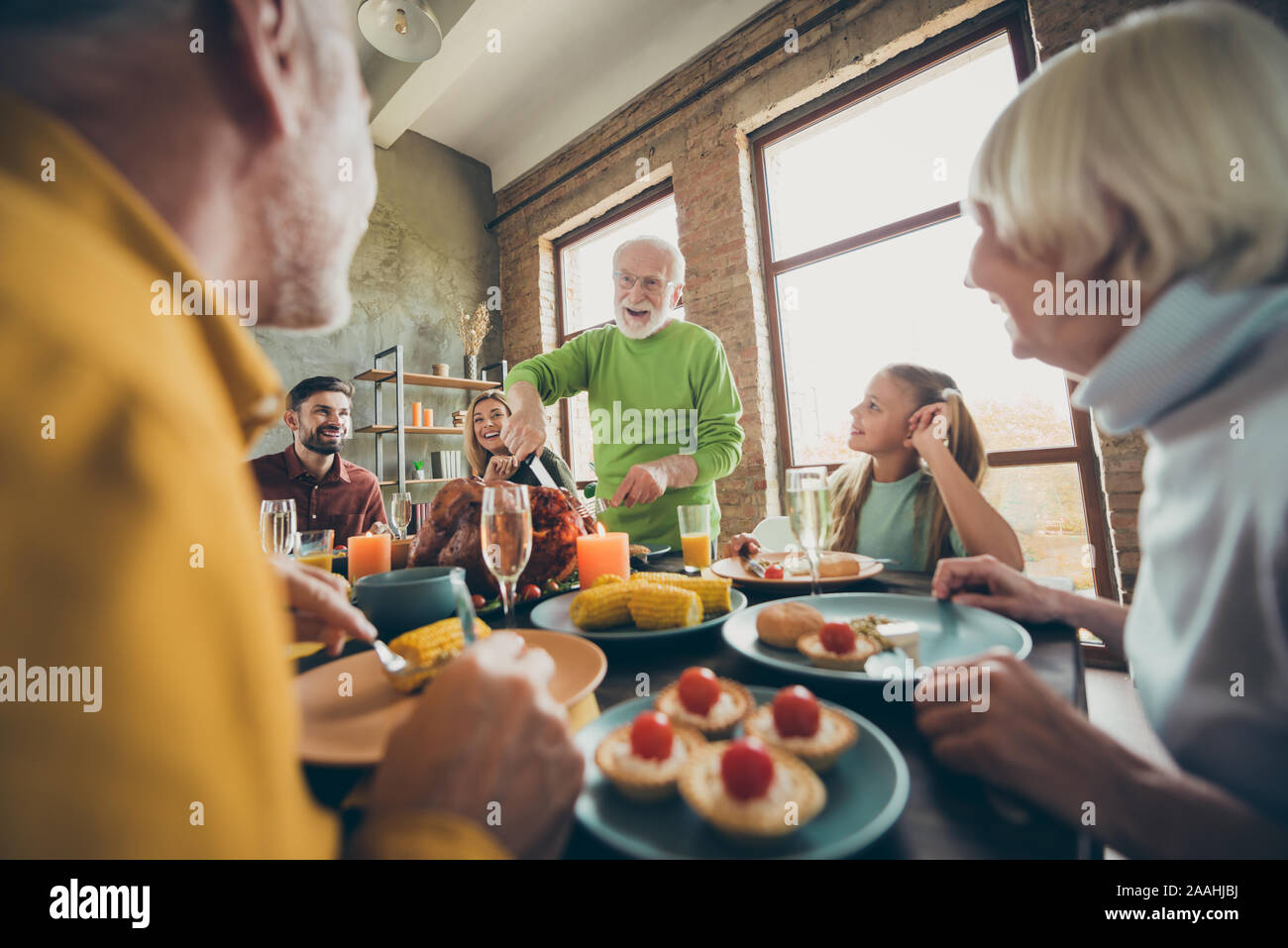 Big family thanksgiving day celebration retired man cut roast chicken meat relatives small