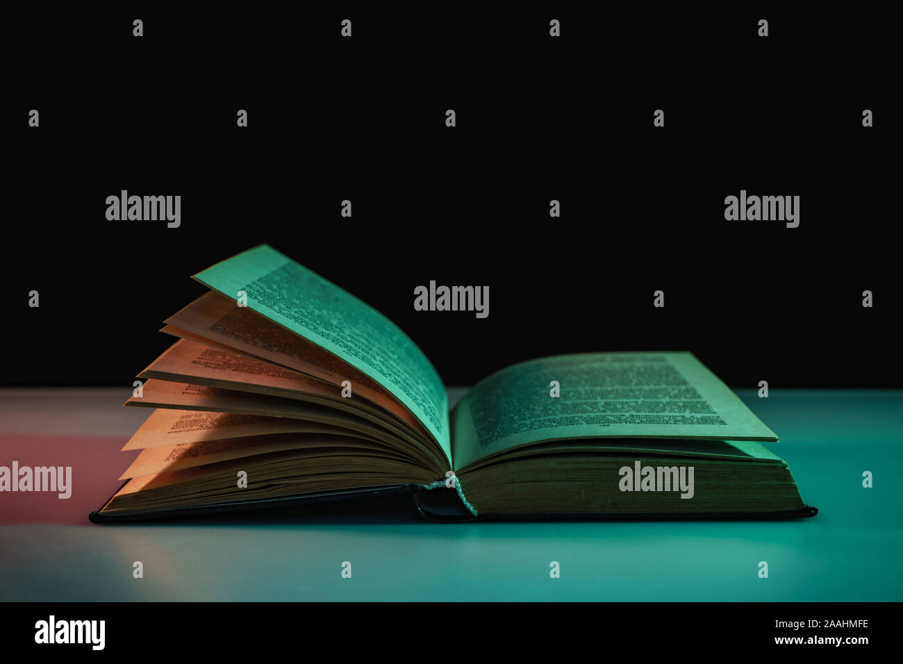 Open Book Colour Beautiful open book in the color light on a table and night background ...