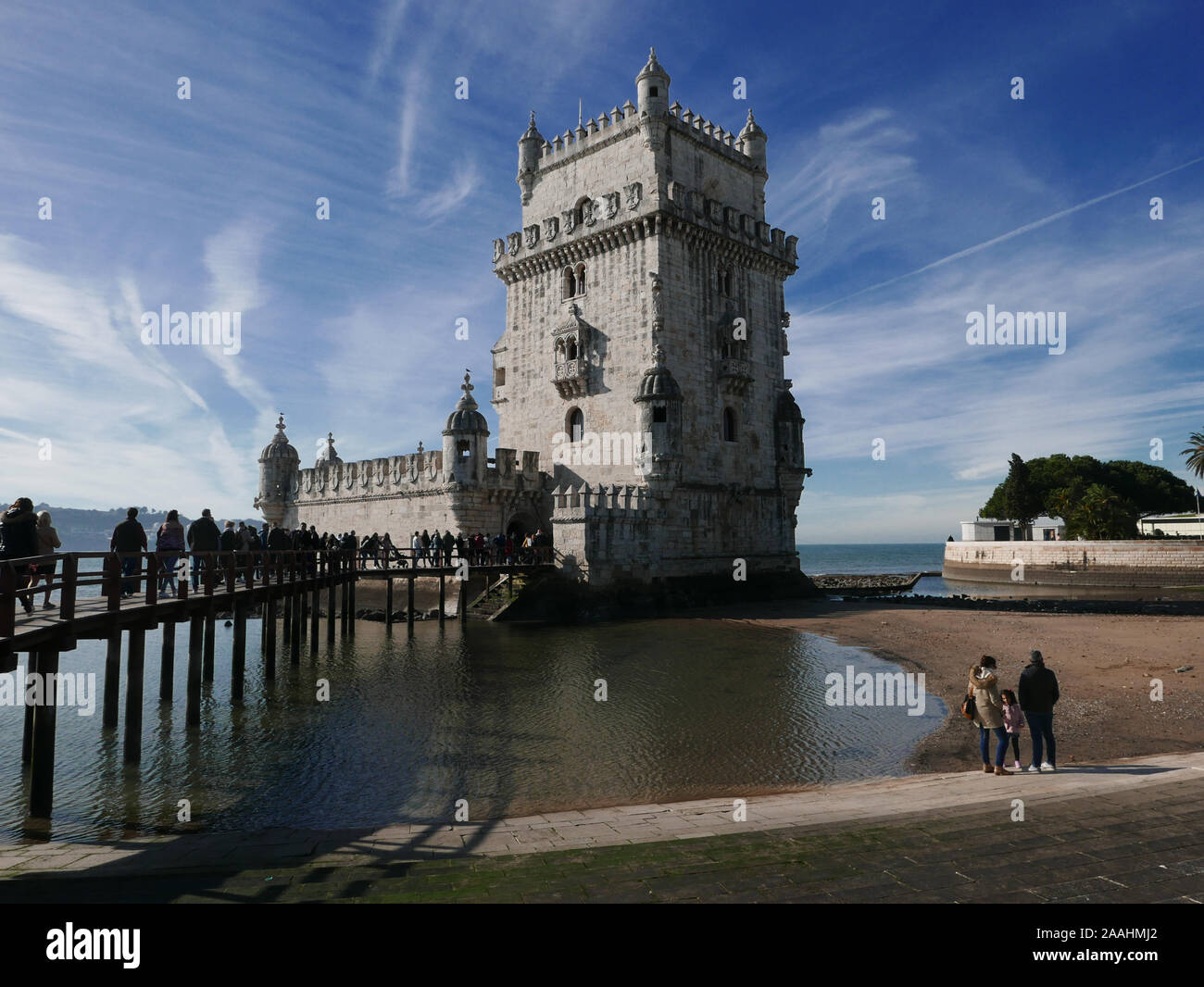 The Belem Tower on the River Tagus in Lisbon Portugal in December with blue sky and some light cloud trails Stock Photo