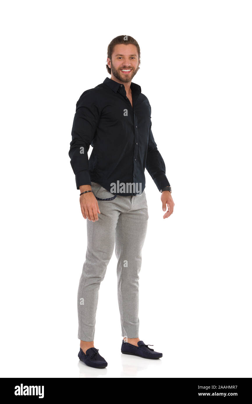 Handsome man in moccasins gray trousers and black shirt is