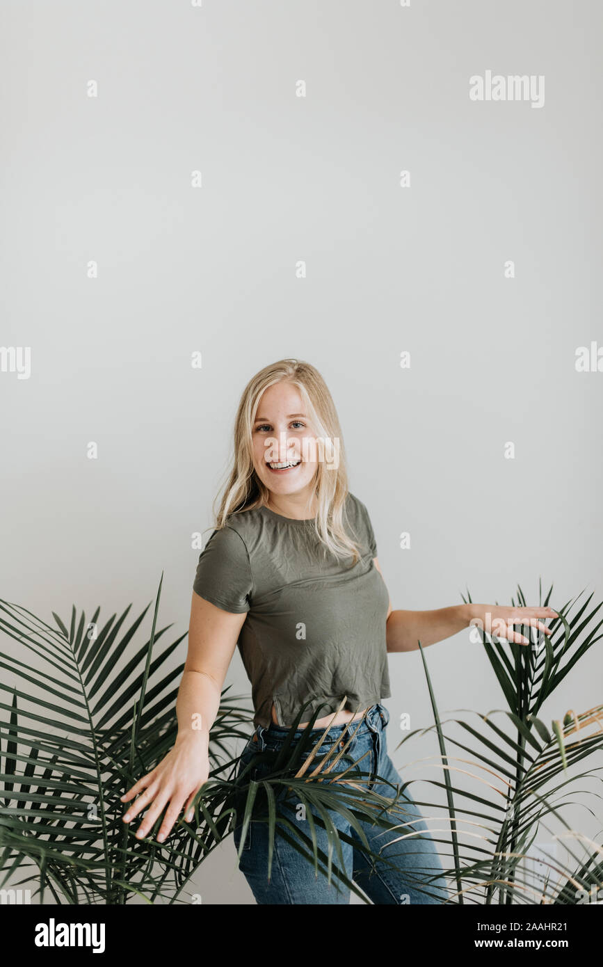 Woman between potted palm plants Stock Photo