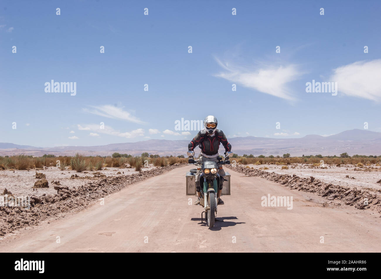 Motorcyclist driving touring motorcycle on dirt road, San Pedro de Atacama, Chile Stock Photo