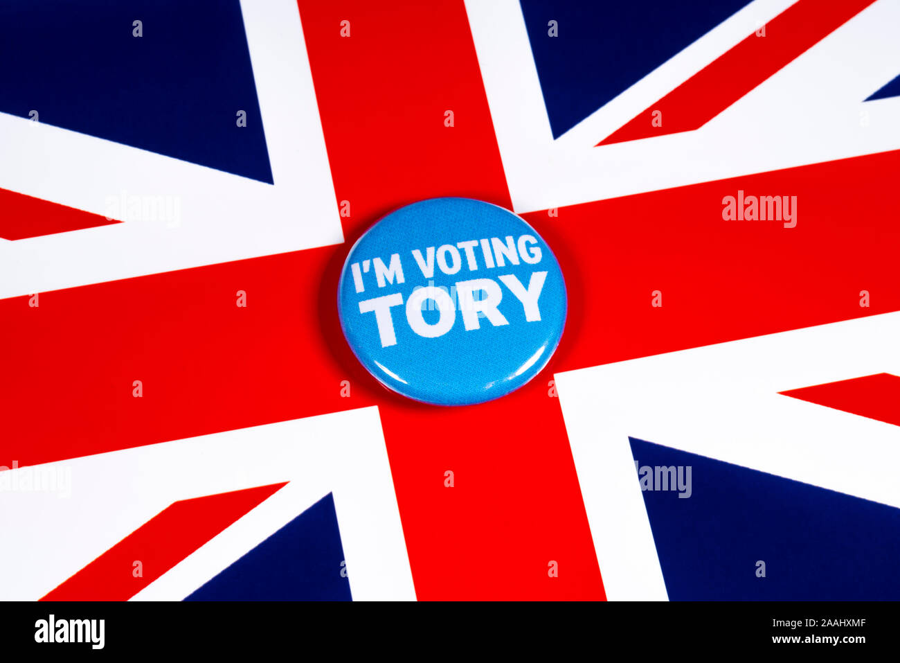 London, UK - November 21st 2019: I’m Voting Tory pin badge, pictured over the United Kingdom flag. The UK General Election is taking place on 12th Dec Stock Photo