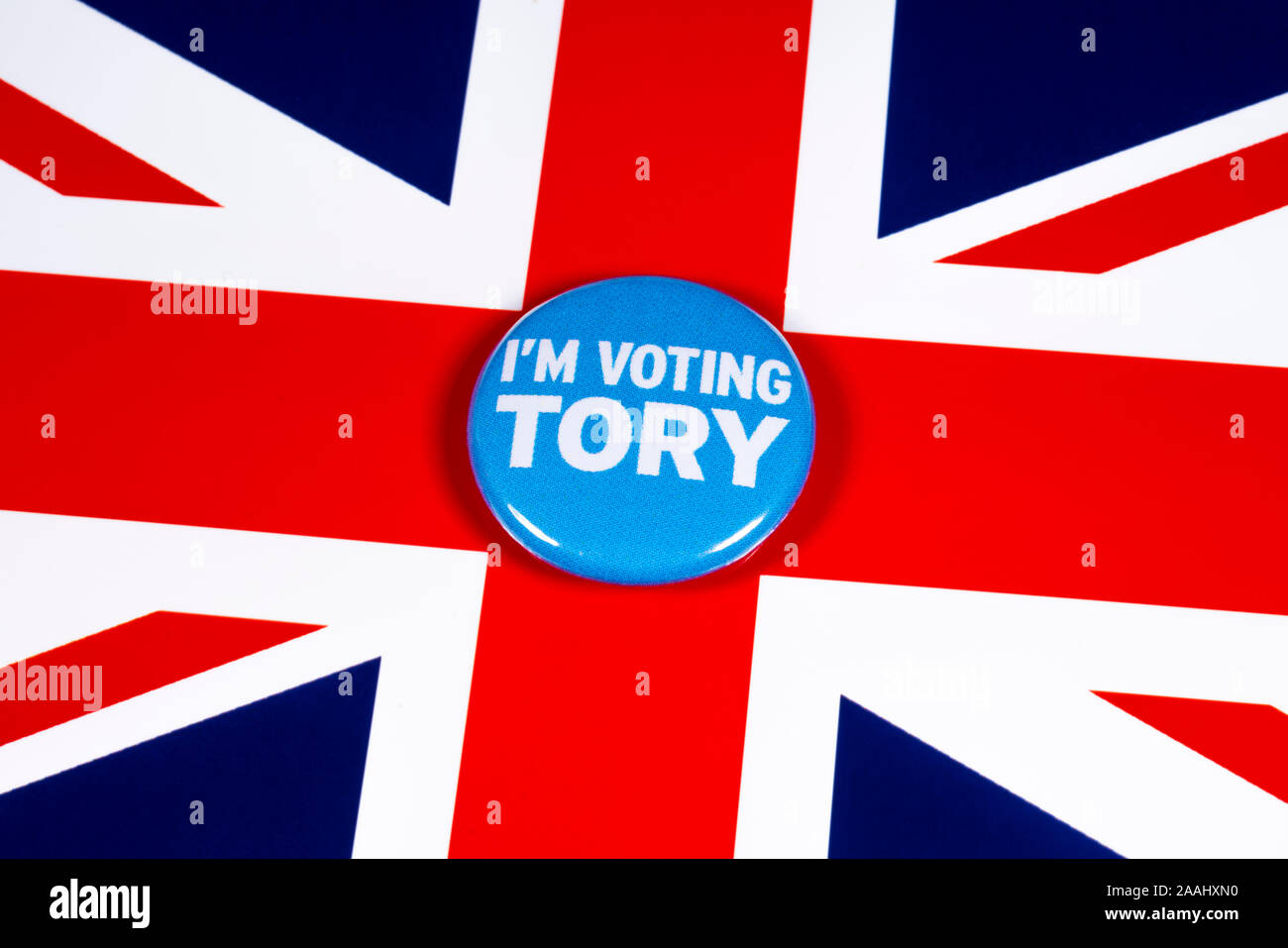 London, UK - November 21st 2019: I’m Voting Tory pin badge, pictured over the United Kingdom flag. The UK General Election is taking place on 12th Dec Stock Photo