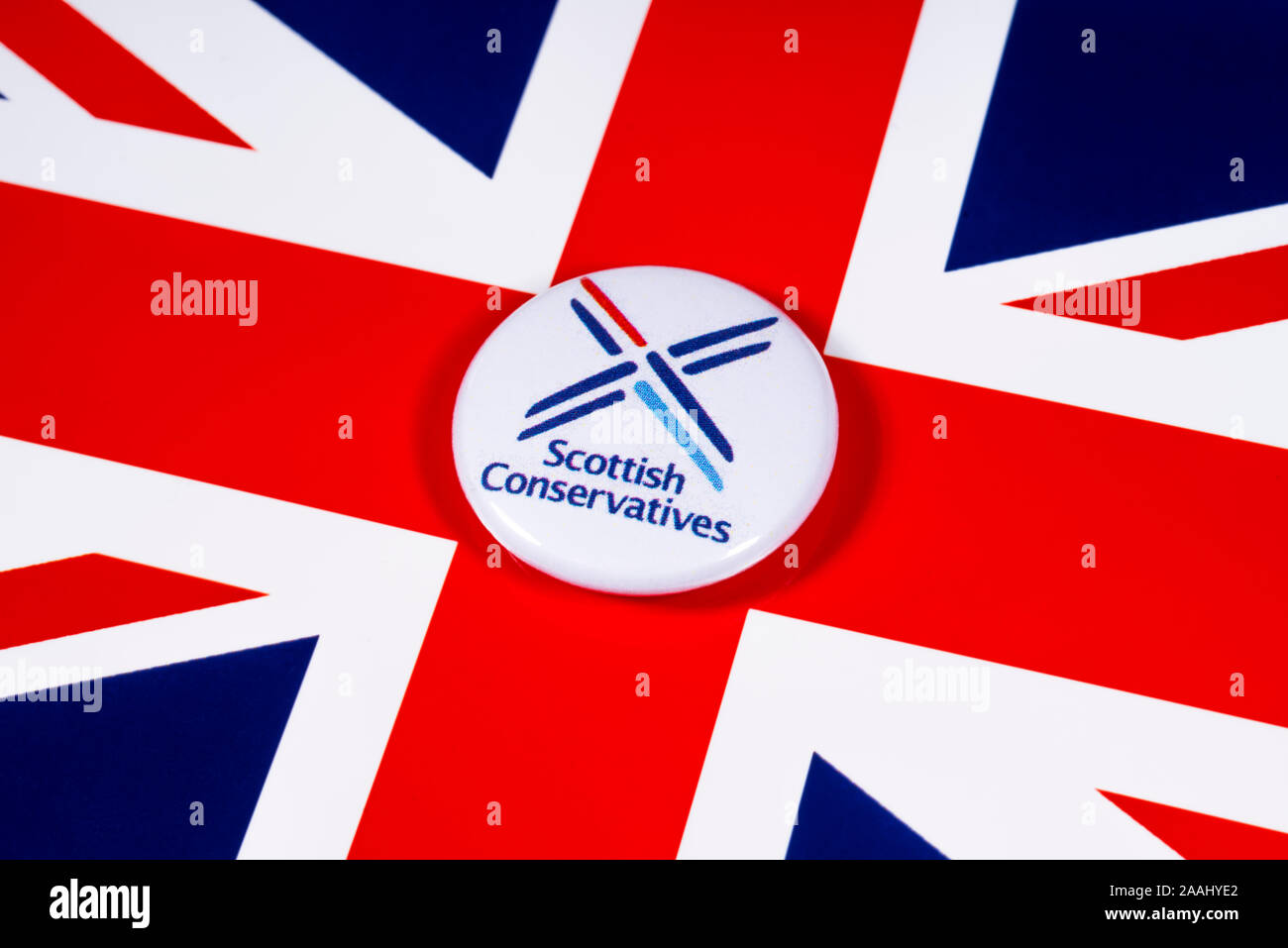 London, UK - November 21st 2019: Scottish Conservative Party pin badge, pictured over the United Kingdom flag. Stock Photo