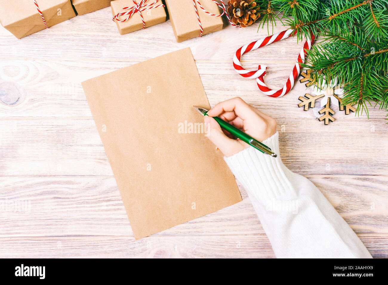 Girl Hand Writing Christmas Letter On Craft Paper With Decorations