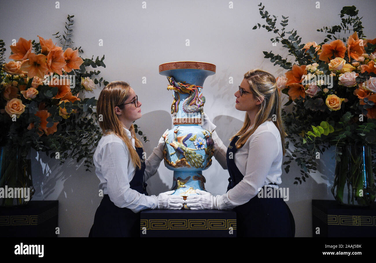 Gallery assistants look at 'An important and rare porcelain vase' from the Imperial Porcelain Factory, 1898, estimated at ??40,000 - ??60,000, during a press preview of the sale of works by some of the most pre-eminent creators of Russian art at Sotheby's in London. Stock Photo