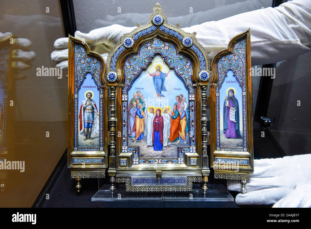 London, UK.  22 November 2019. A technician presents 'A silver-gilt, cloisonné and pictorial enamel triptych icon', 1899-1908, by Khlebnikov, Moscow (Est. GBP100-150k) at the preview for the upcoming sales of Russian artworks at Sotheby's New Bond Street.  The Russian Pictures and Works of Art, Fabergé and Icons sales take place on 26 November.  Credit: Stephen Chung / Alamy Live News Stock Photo