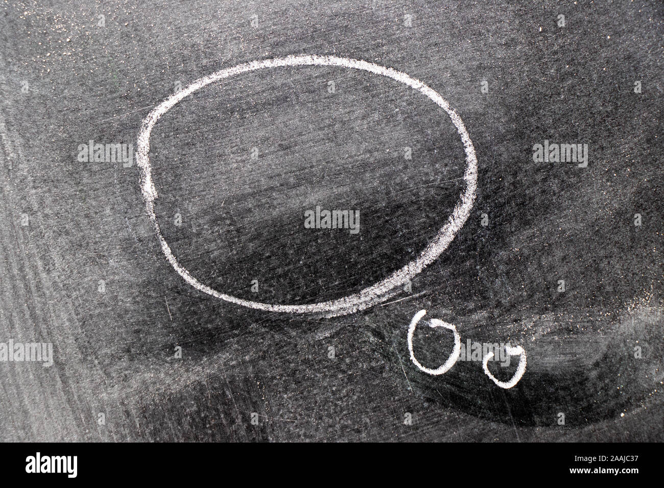 White color chalk hand drawing as round speech bubble shape on black ...