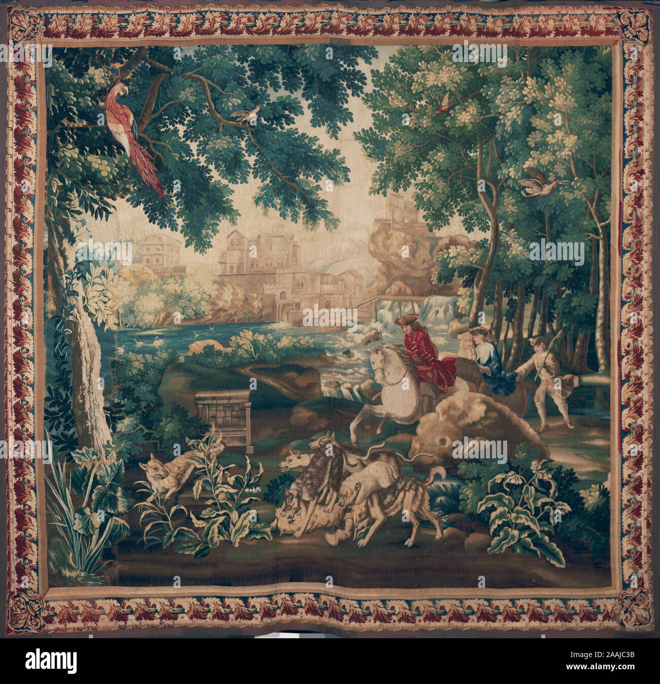 Tapestry Dimensions: H 10' x W 11'. Wolf, lying on its back, is attacked by 3 dogs as another is chased by 2 dogs, 3 men approach on horseback followed by man on foot carrying gun over his shoulder; river & town in background Stock Photo