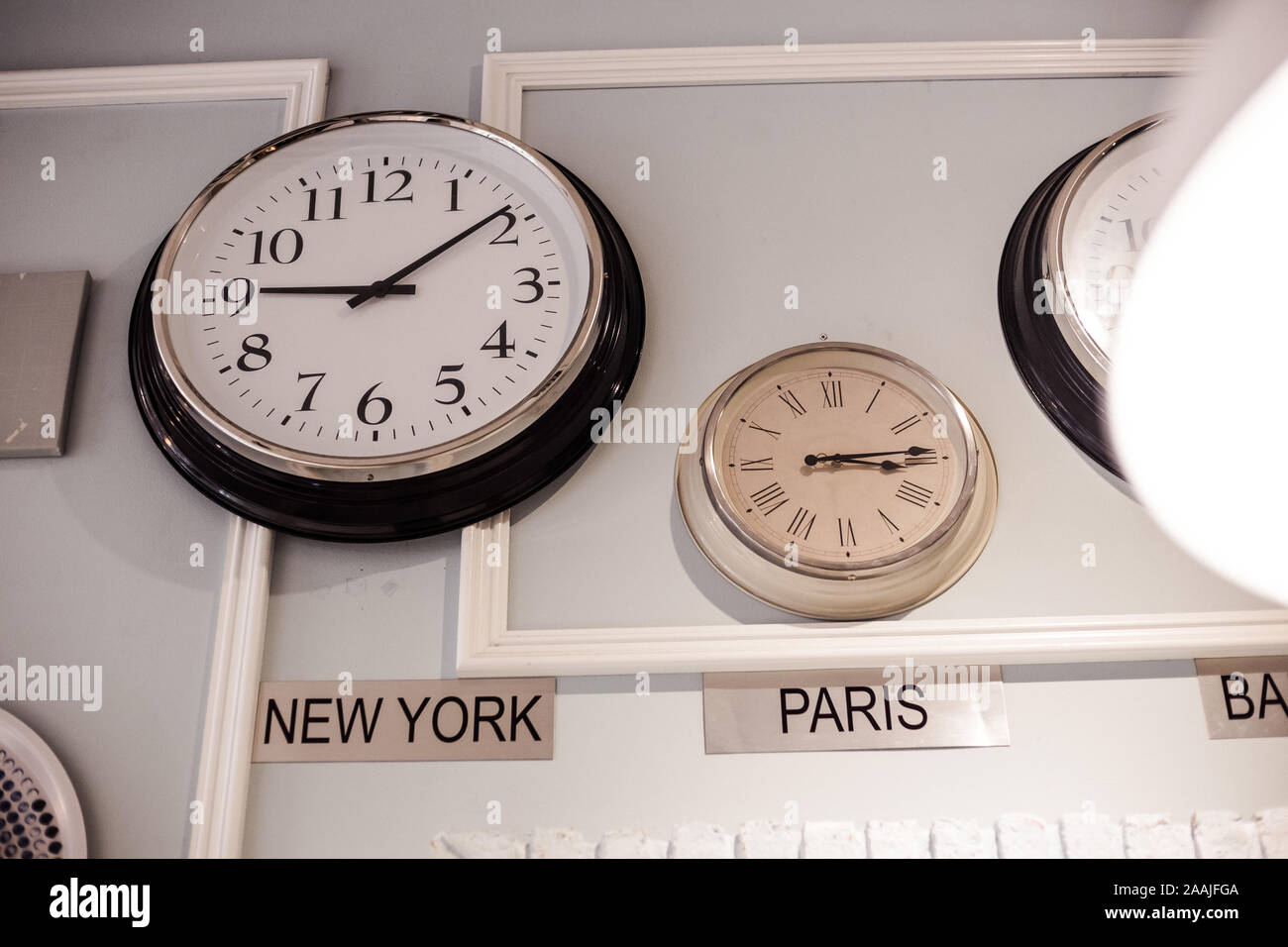 international clock with different time zone for New York and Paris are hang on the wall Stock Photo