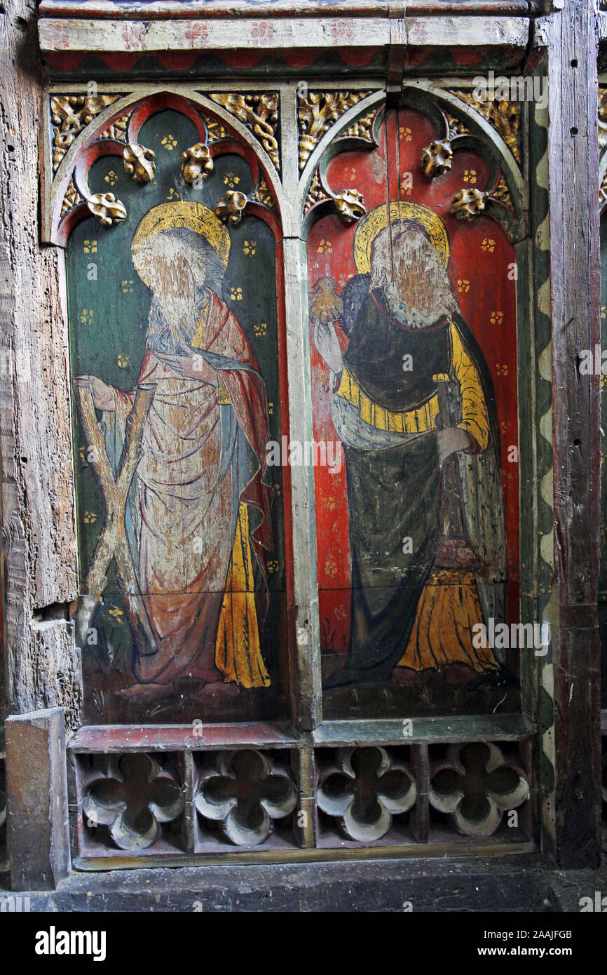 Painted rood screen depicting saints Andrew and James the Greater heavily defaced during the iconoclasm of the reformation, St Peter's Church, Belaugh Stock Photo