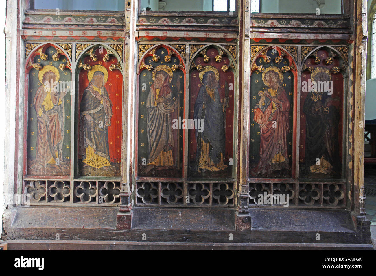 Painted rood screen depicting various saints, heavily defaced during the iconoclasm of the English Civil War, St Peter's Church, Belaugh, Norfolk Stock Photo