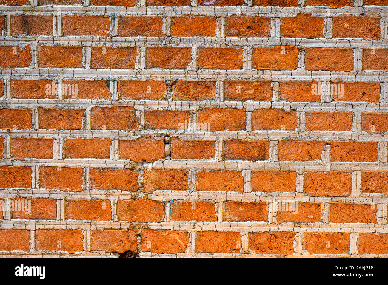 Texture background of red bricks wall, a continuous vertical brick  structure that encloses or divides an area of land. Stock Photo