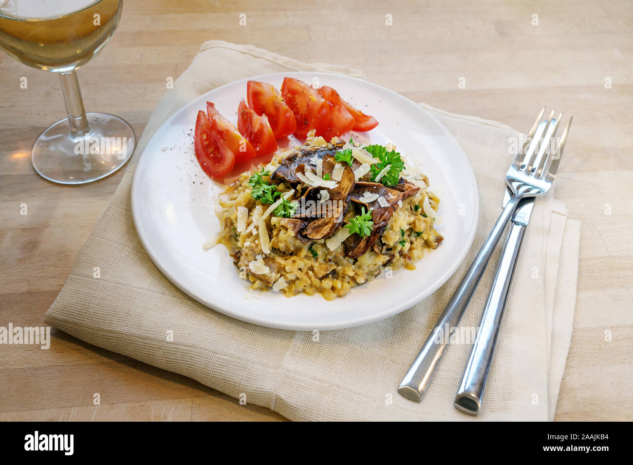 low carb diet meal, risotto made from cauliflower with dried porcini mushrooms, garnished with parsley and parmesan cheese on a plate on a wooden tabl Stock Photo