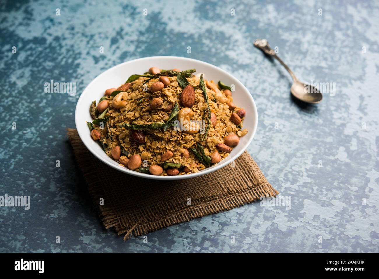 Oats Chivda / Chiwda is a healthy indian recipe with added chilli, peanuts, cashew, almond and curry leaf for flavour. Selective focus Stock Photo