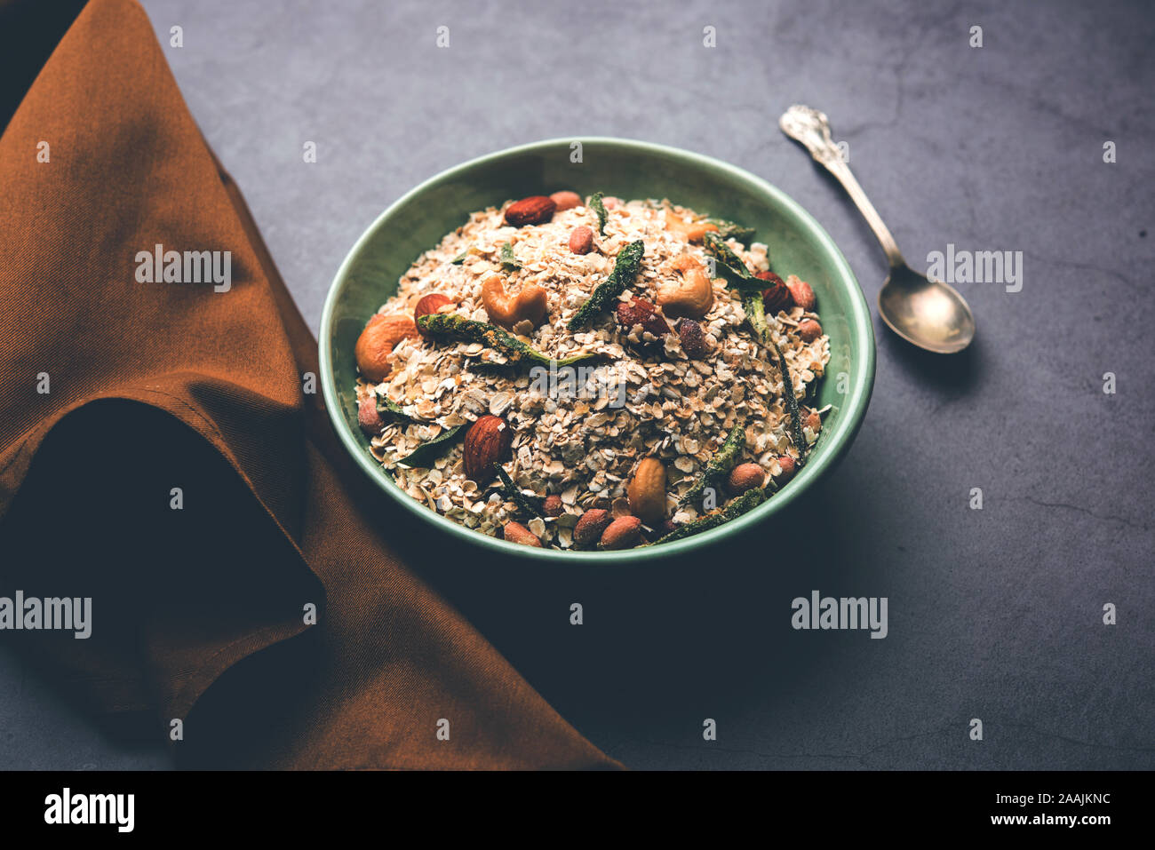 Oats Chivda / Chiwda is a healthy indian recipe with added chilli, peanuts, cashew, almond and curry leaf for flavour. Selective focus Stock Photo