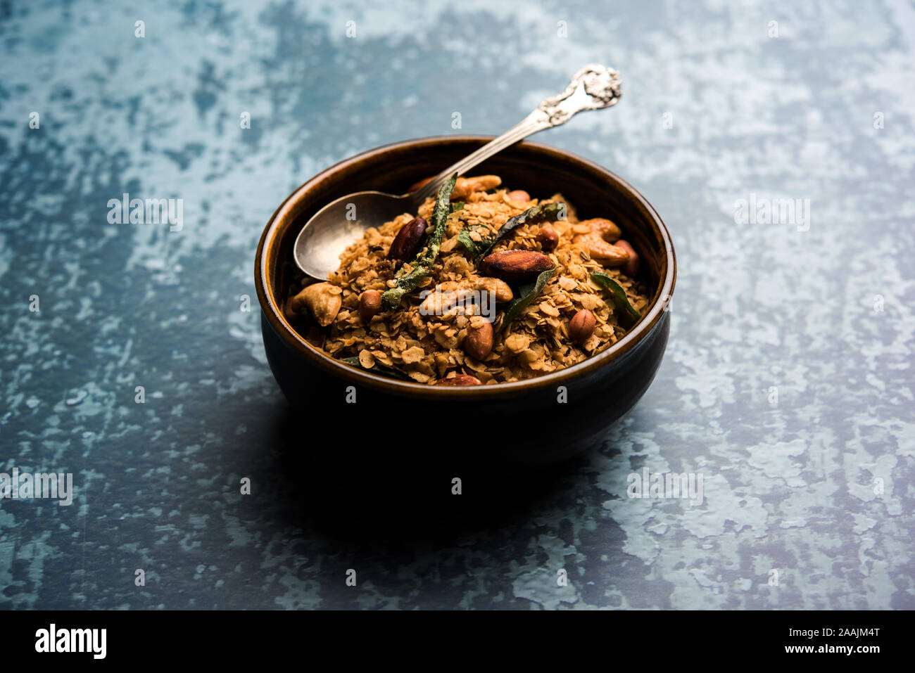 Oats Chivda / Chiwda is a healthy indian recipe with added chilli, peanuts, cashew, almond and curry leaf for flavour. Selective focus Stock Photo