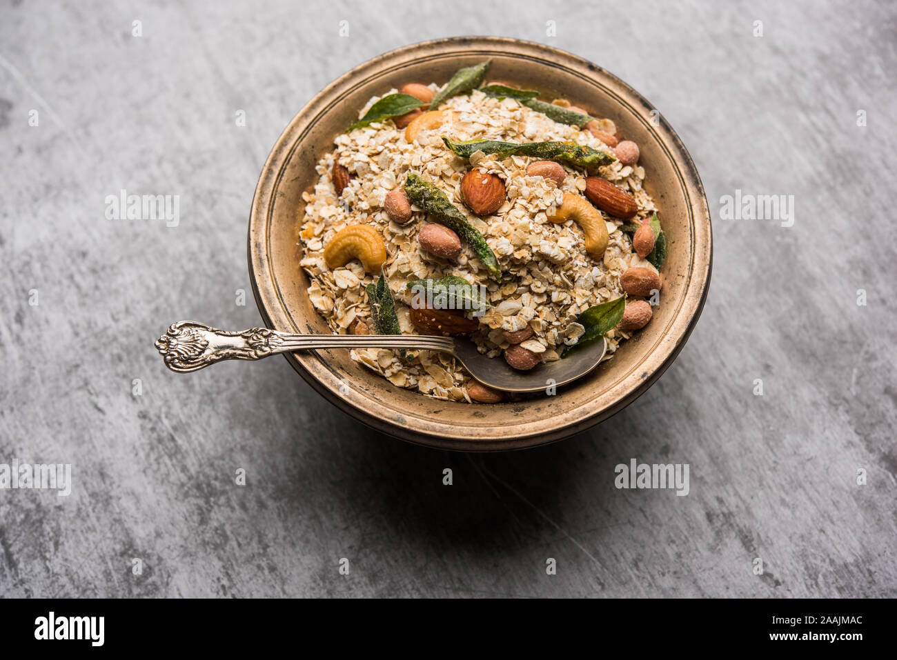 Oats Chivda / Chiwda is a healthy indian recipe with added chilli, peanuts, cashew, almond and curry leaf for flavour. Selective focus Stock Photo