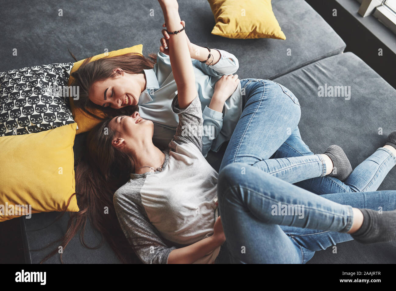 Two cute smiling twins sisters holding smartphone and making selfie 