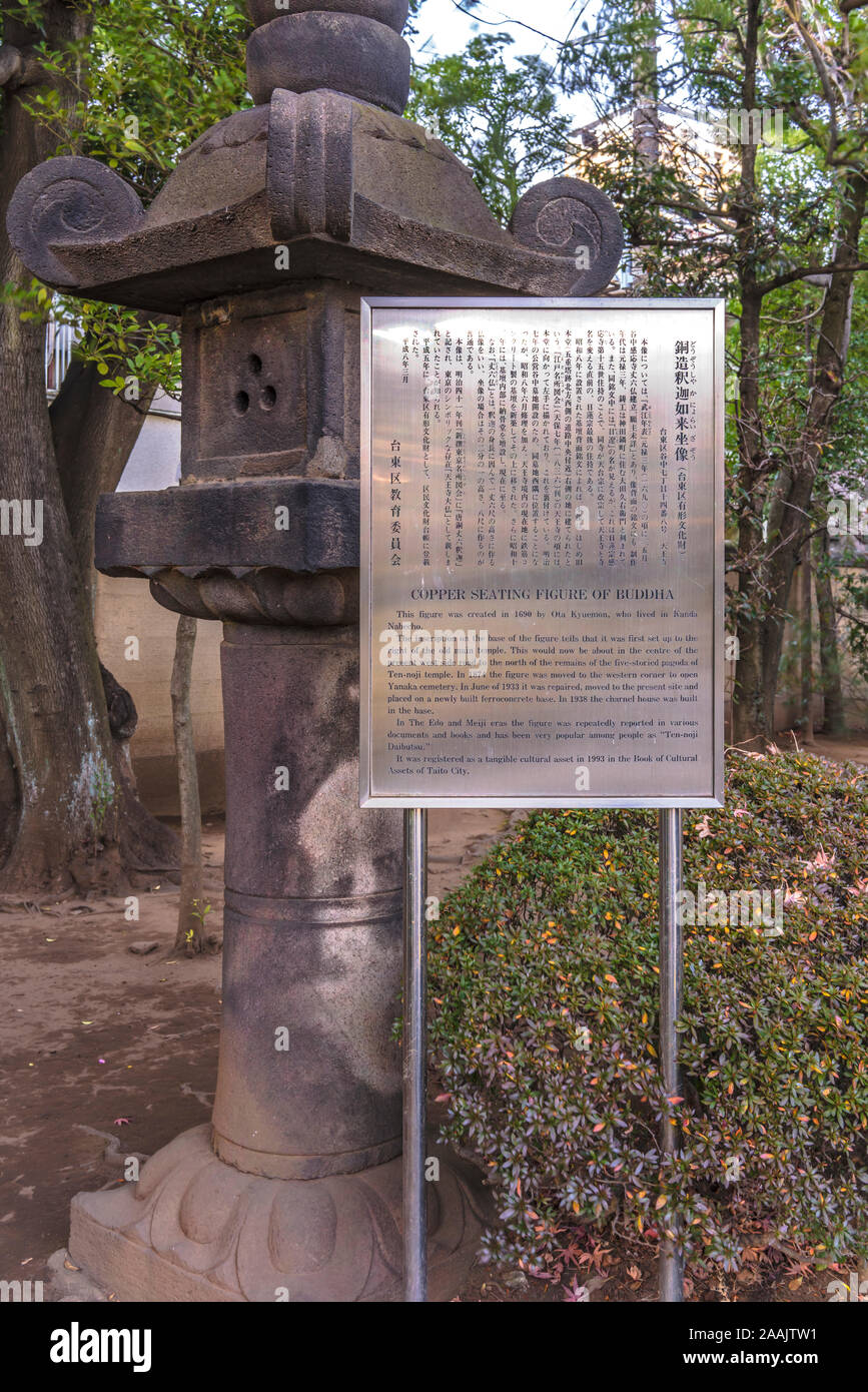 Kasuga stone lantern and metal information panel describing in Japanese and English the story of the grand Buddha Shaka Nyorai bronze statue in the Te Stock Photo