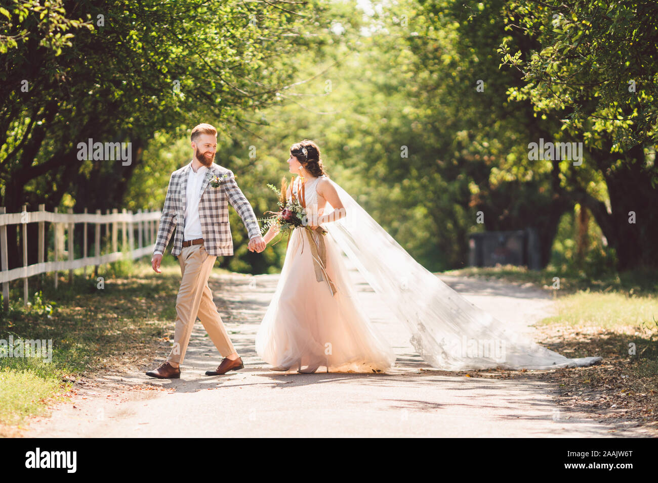 Lovely wedding couple wood forest. Bride and groom, follow me, married couple, woman in white wedding dress and veil. Rustic outdoors love story Stock Photo