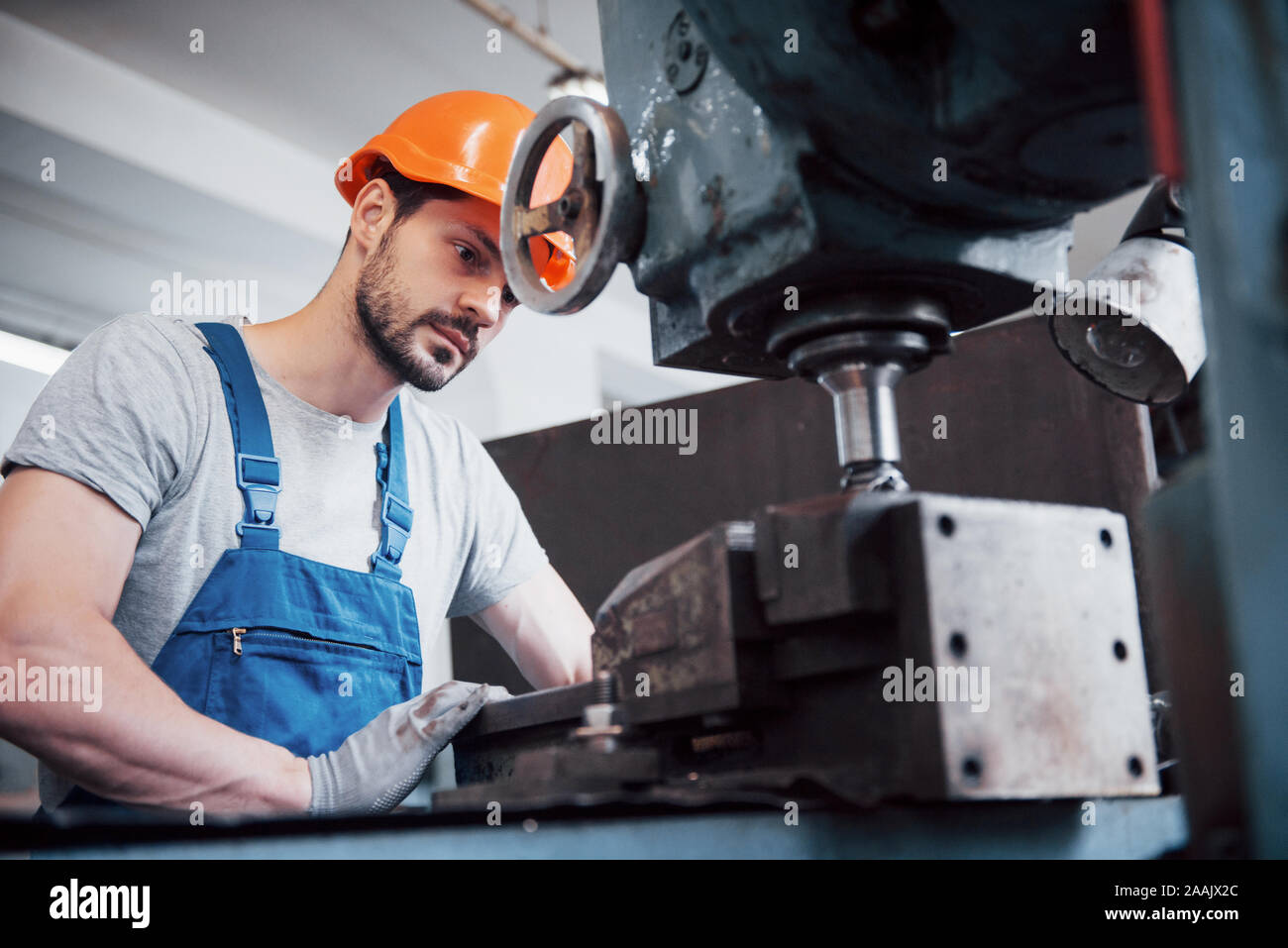 Portrait of a young worker in a hard hat at a large waste recycling