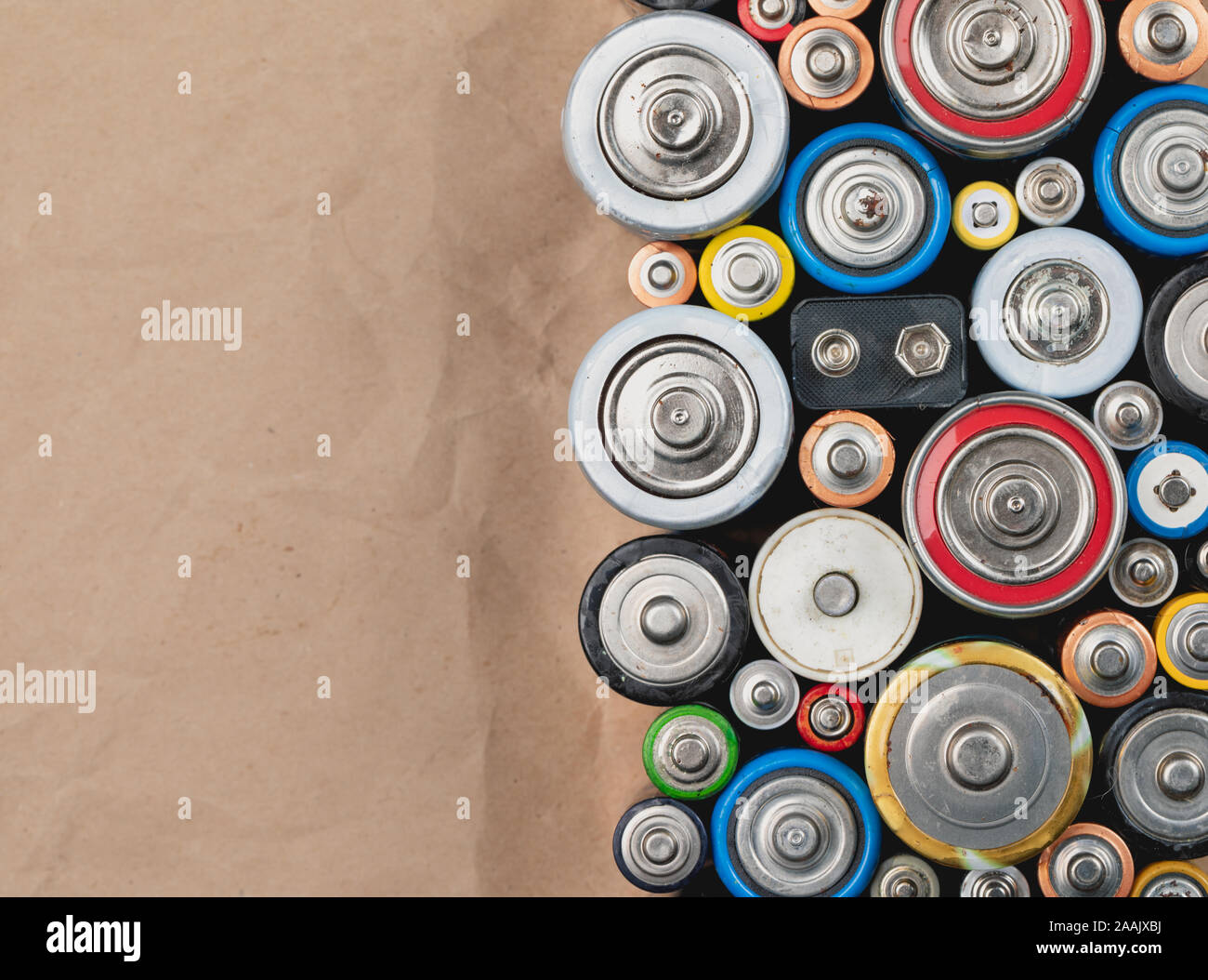 Used Alkaline batteries of different types (C AA AAA D 9V) on wrinkled