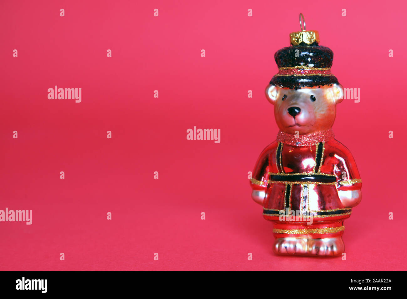 Christmas Decoration Bauble, a Bear dressed as a Beefeater for Christmas Isolated on a red background with copy space Stock Photo