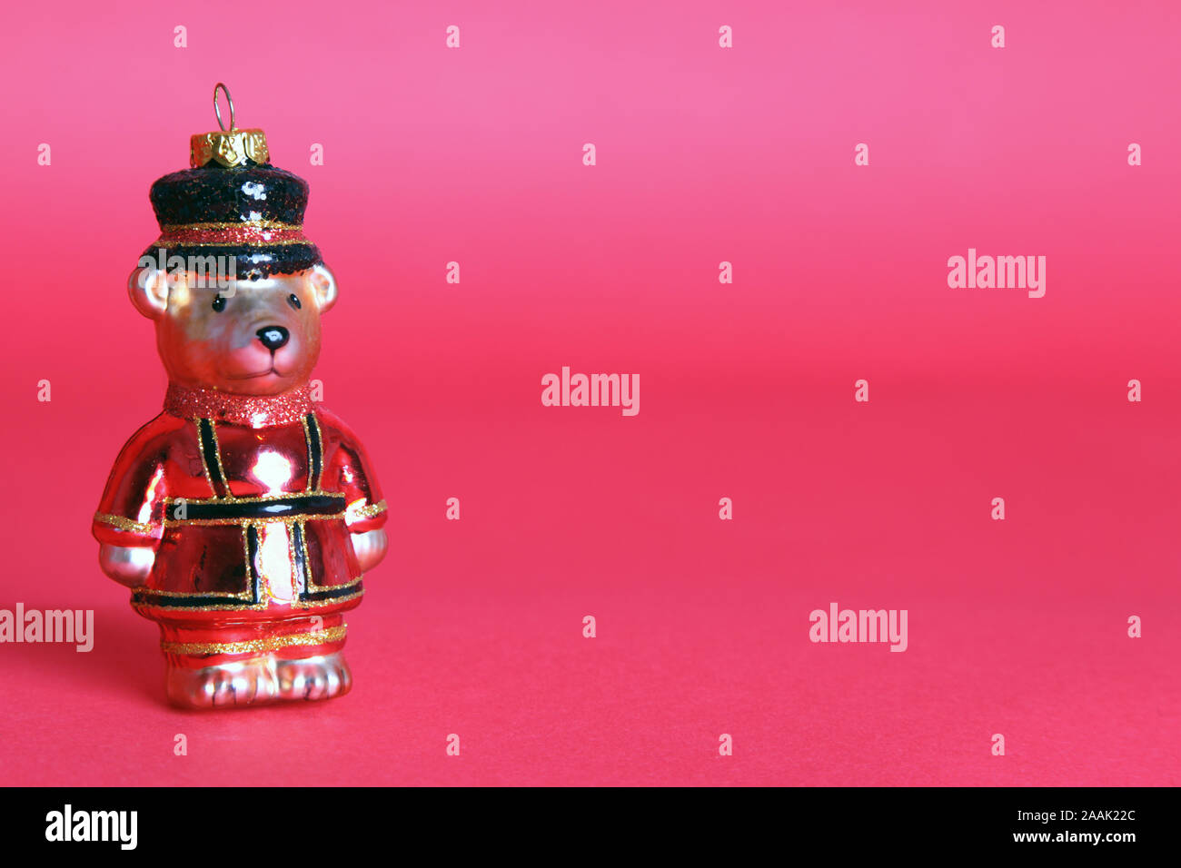 Christmas Decoration Bauble, a Bear dressed as a Beefeater for Christmas Isolated on a red background with copy space Stock Photo