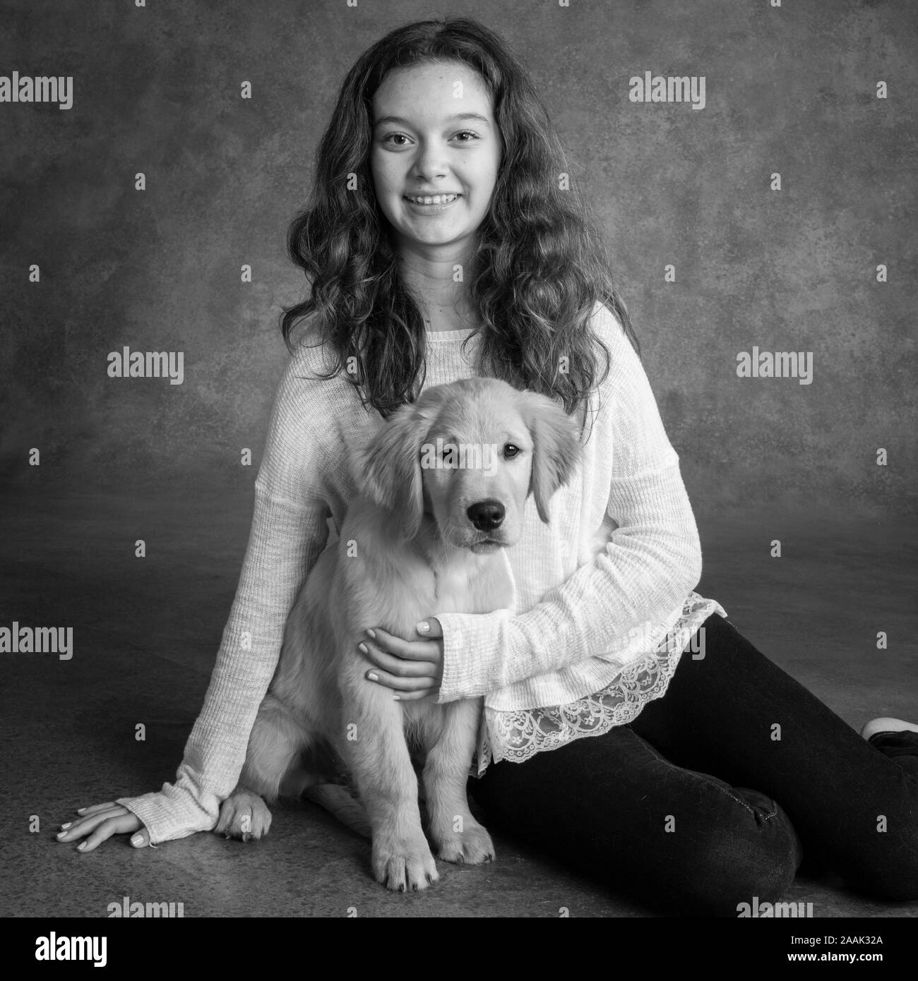Studio portrait of teenage girl with Golden Retriever puppy Stock Photo ...