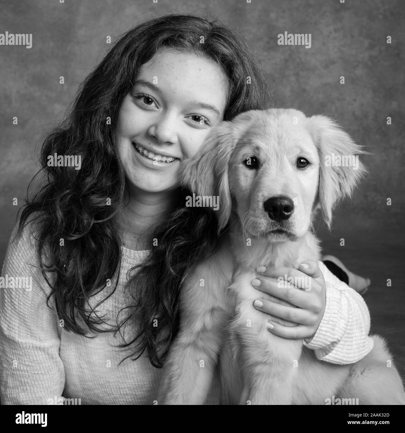 Studio portrait of teenage girl with Golden Retriever puppy Stock Photo ...