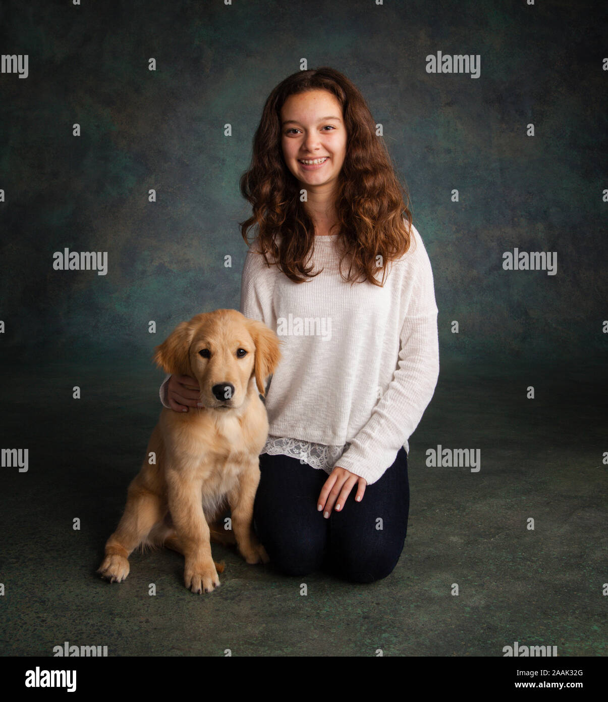 Studio portrait of teenage girl with Golden Retriever puppy Stock Photo