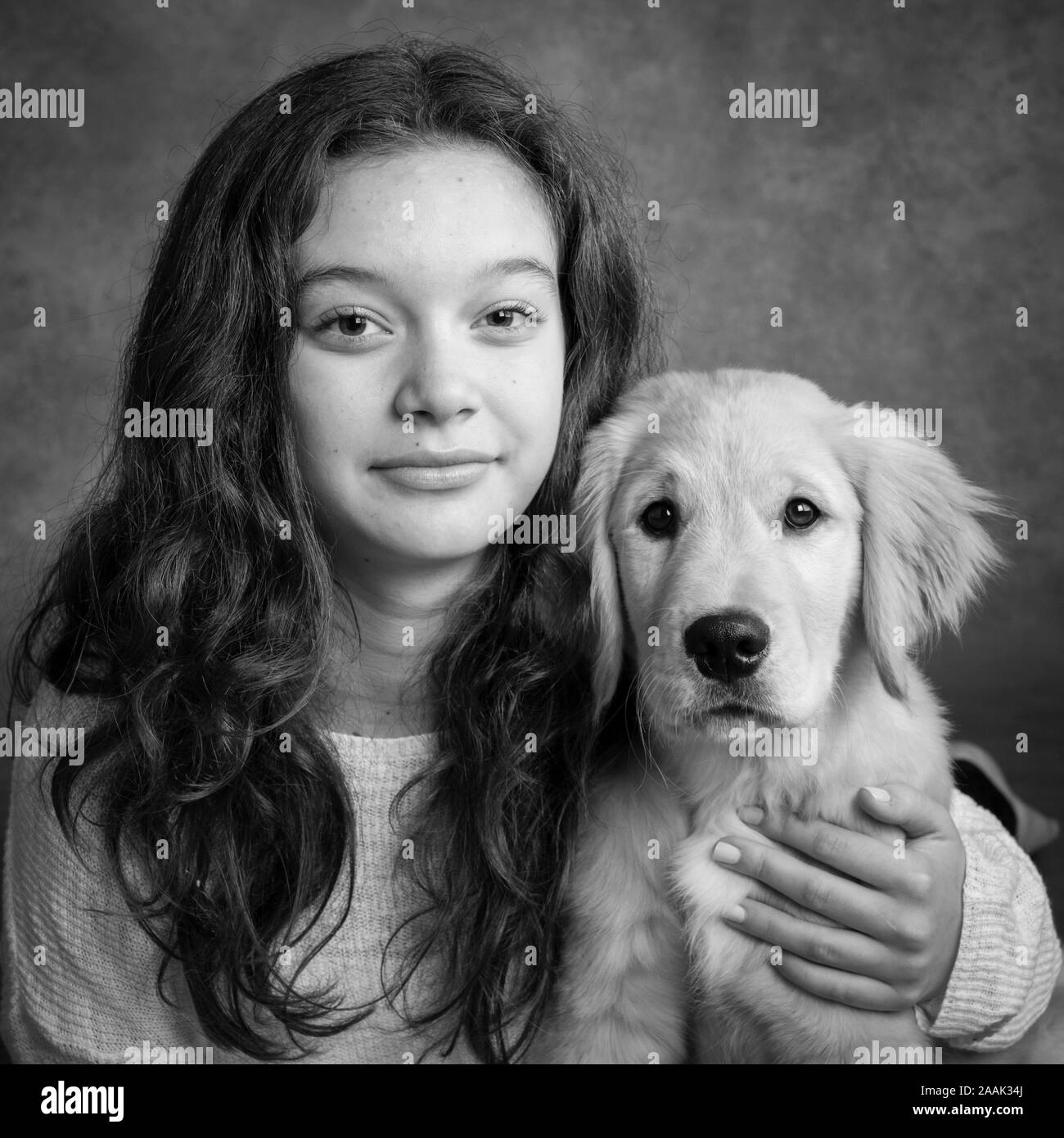 Studio portrait of teenage girl with Golden Retriever puppy Stock Photo ...