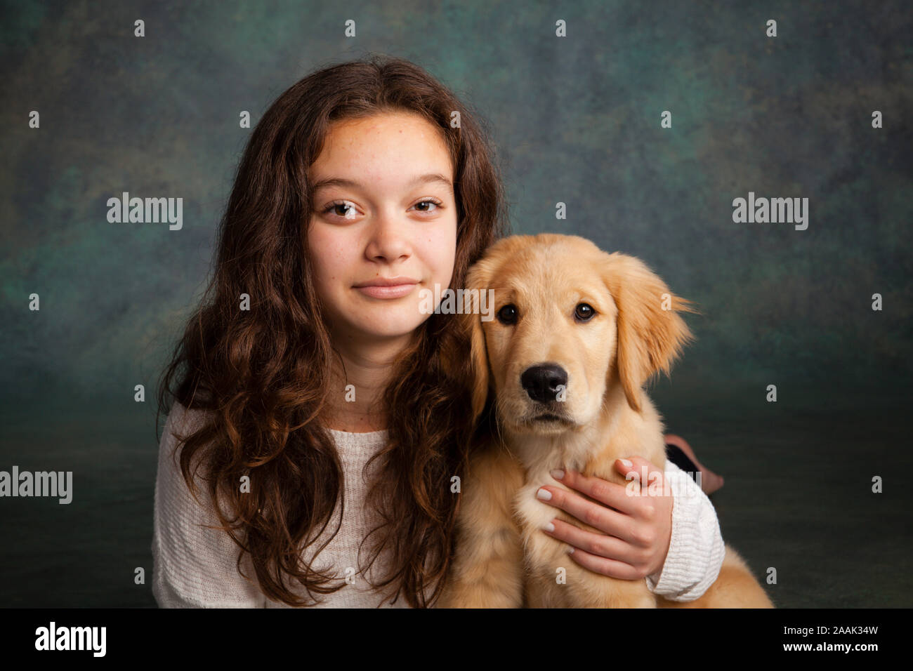 Studio portrait of teenage girl with Golden Retriever puppy Stock Photo ...