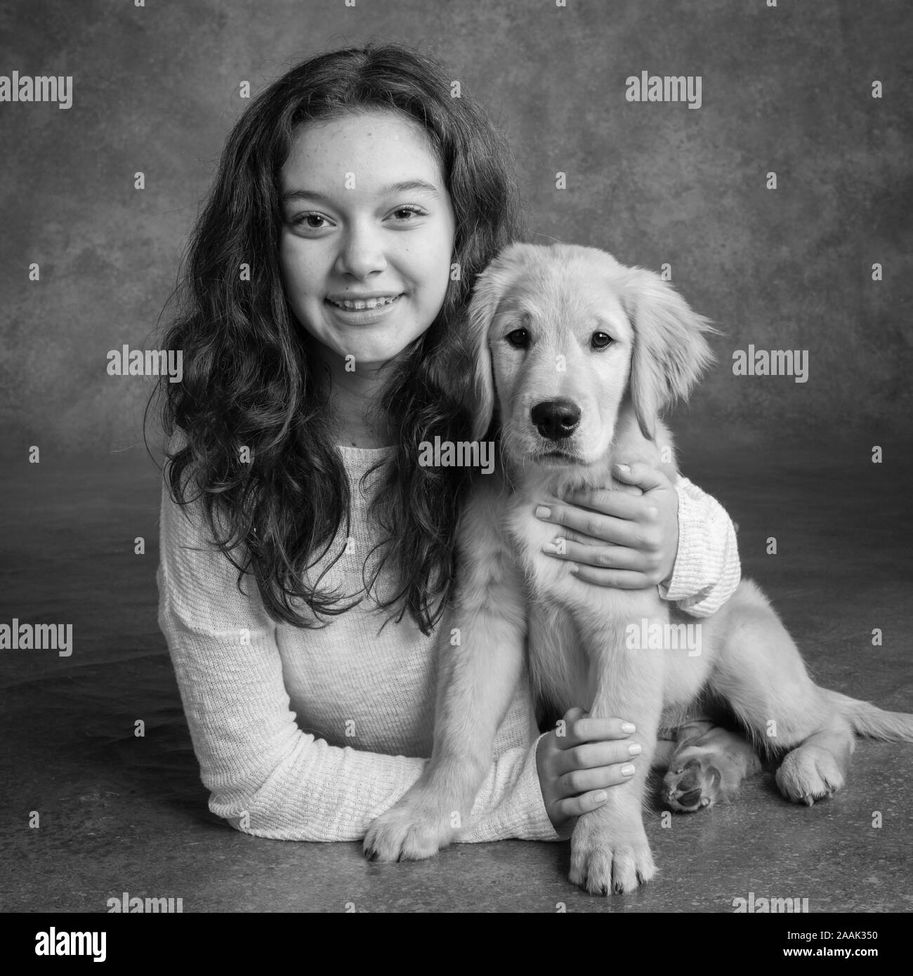 Studio portrait of teenage girl with Golden Retriever puppy Stock Photo ...