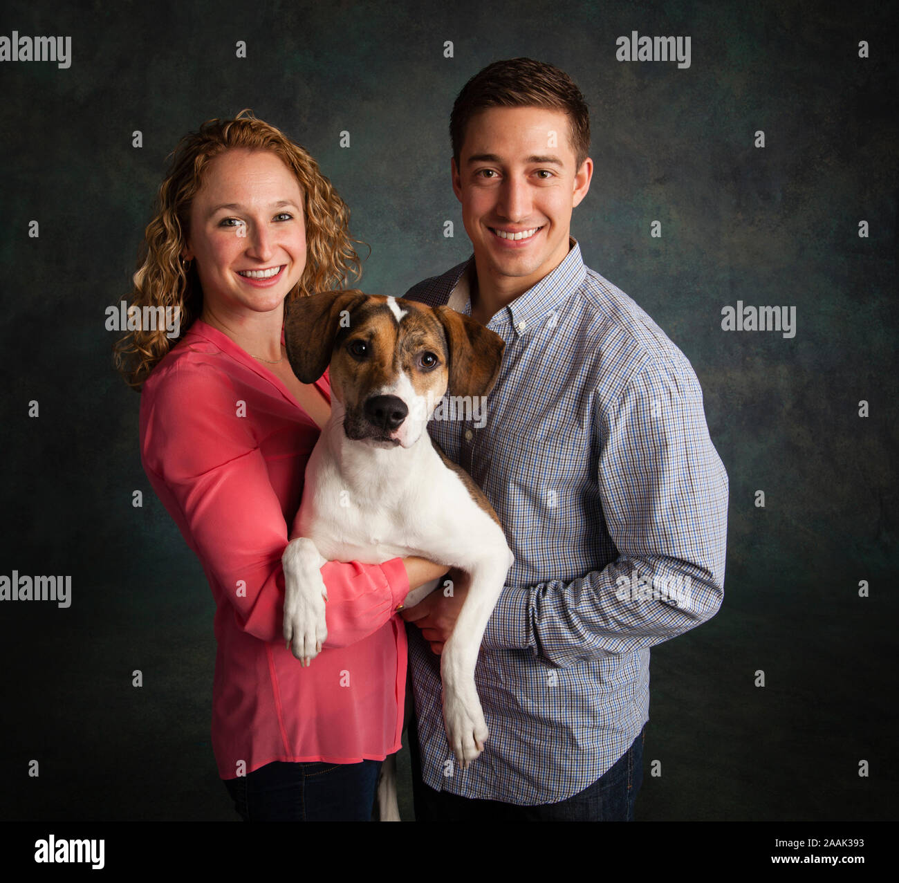 Studio portrait of couple with mixed breed dog Stock Photo