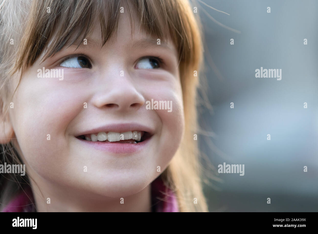Portrait of happy child girl in warm clothes in autumn outdoors. Stock Photo